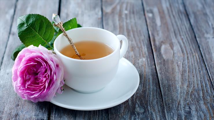 Kawa i herbata - tapeta-roza-polozona-na-talerzyku-obok-filizanki-z-herbata.jpg